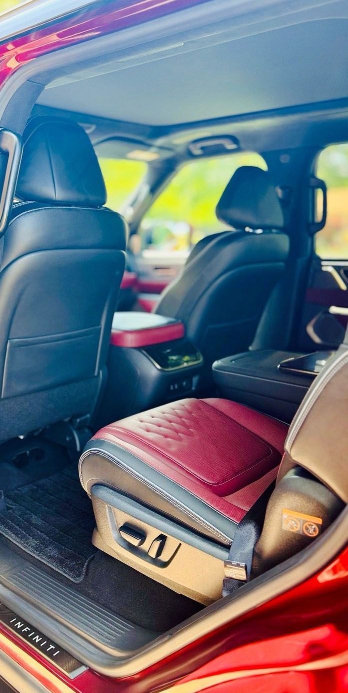 Interior view of a red car with black and burgundy leather seats and a sunroof.