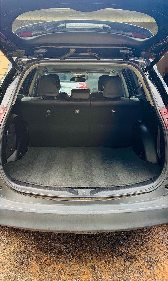 Open cargo area of a gray SUV, showing the back seats and trunk space.
