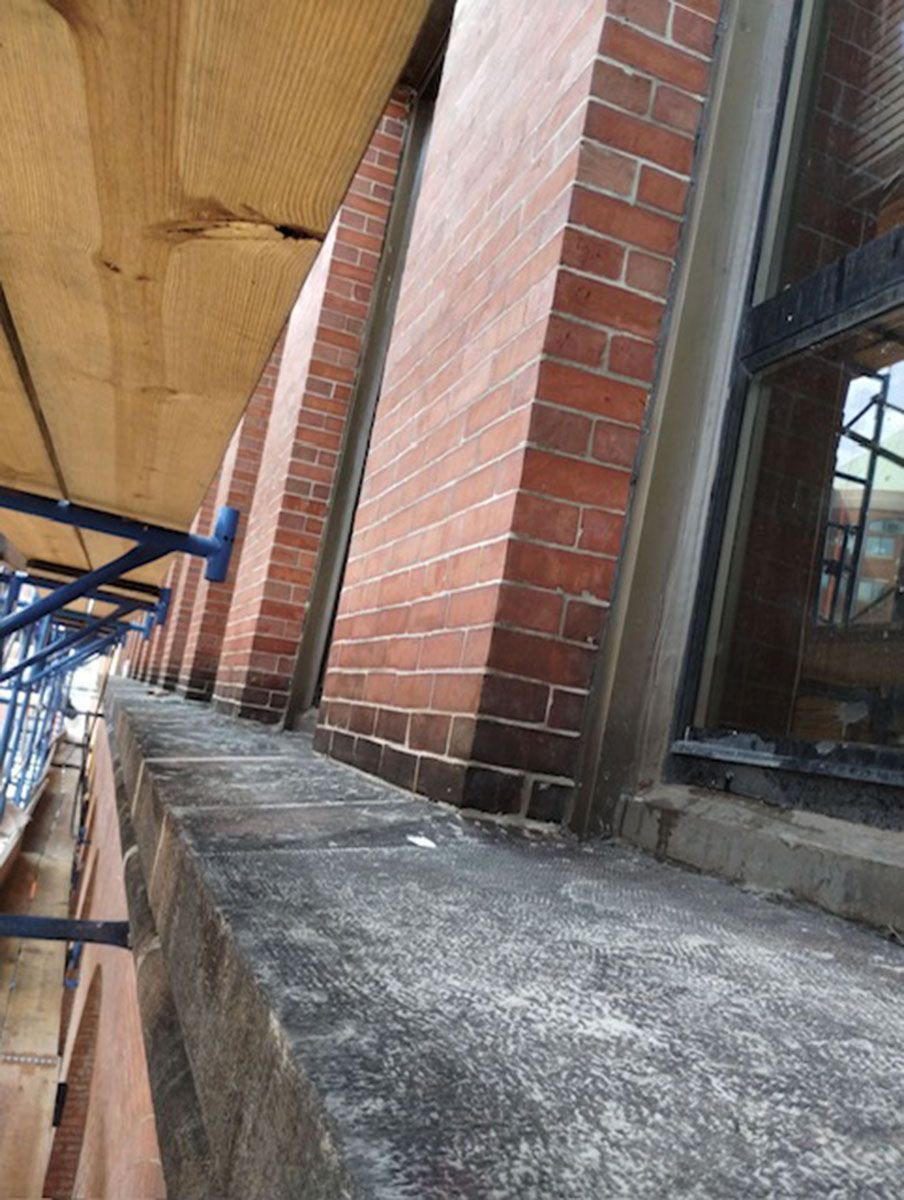 A brick building with a window and scaffolding on the side of it