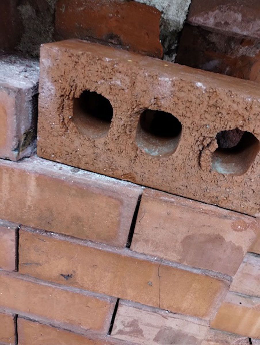 A close-up of a brick wall with holes in it