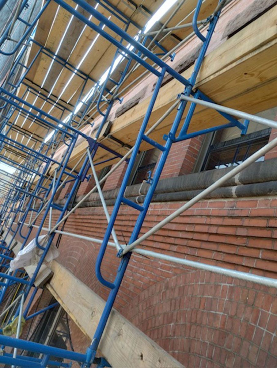 A brick building with blue scaffolding on it