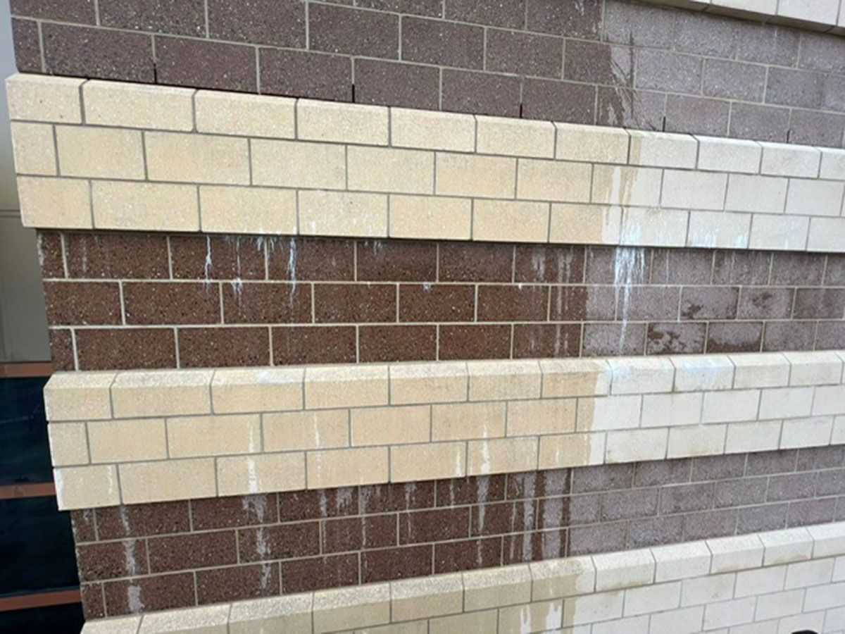 A brick wall with a brown and white stripe on it