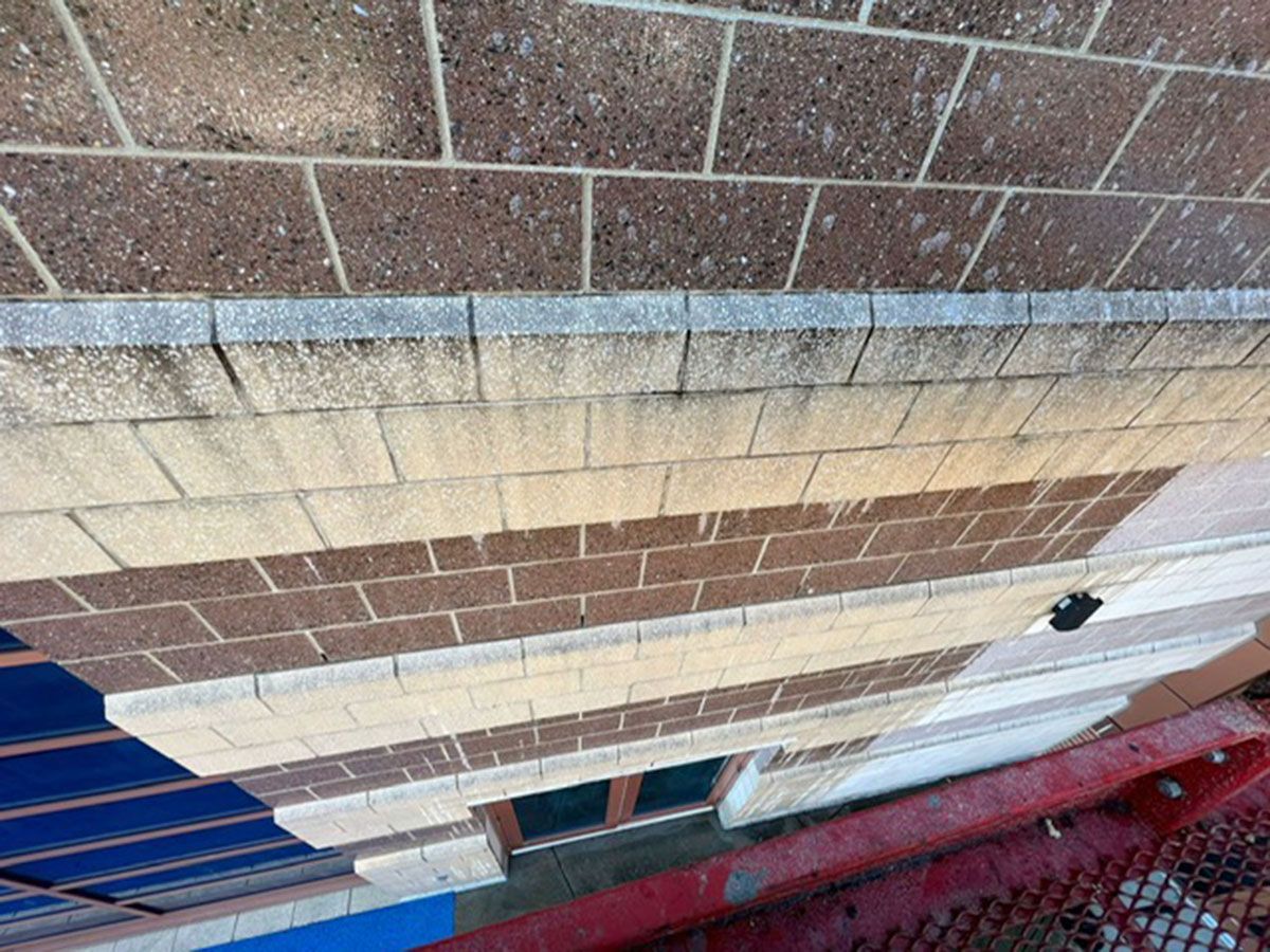 A brick building with a red fence in front of it