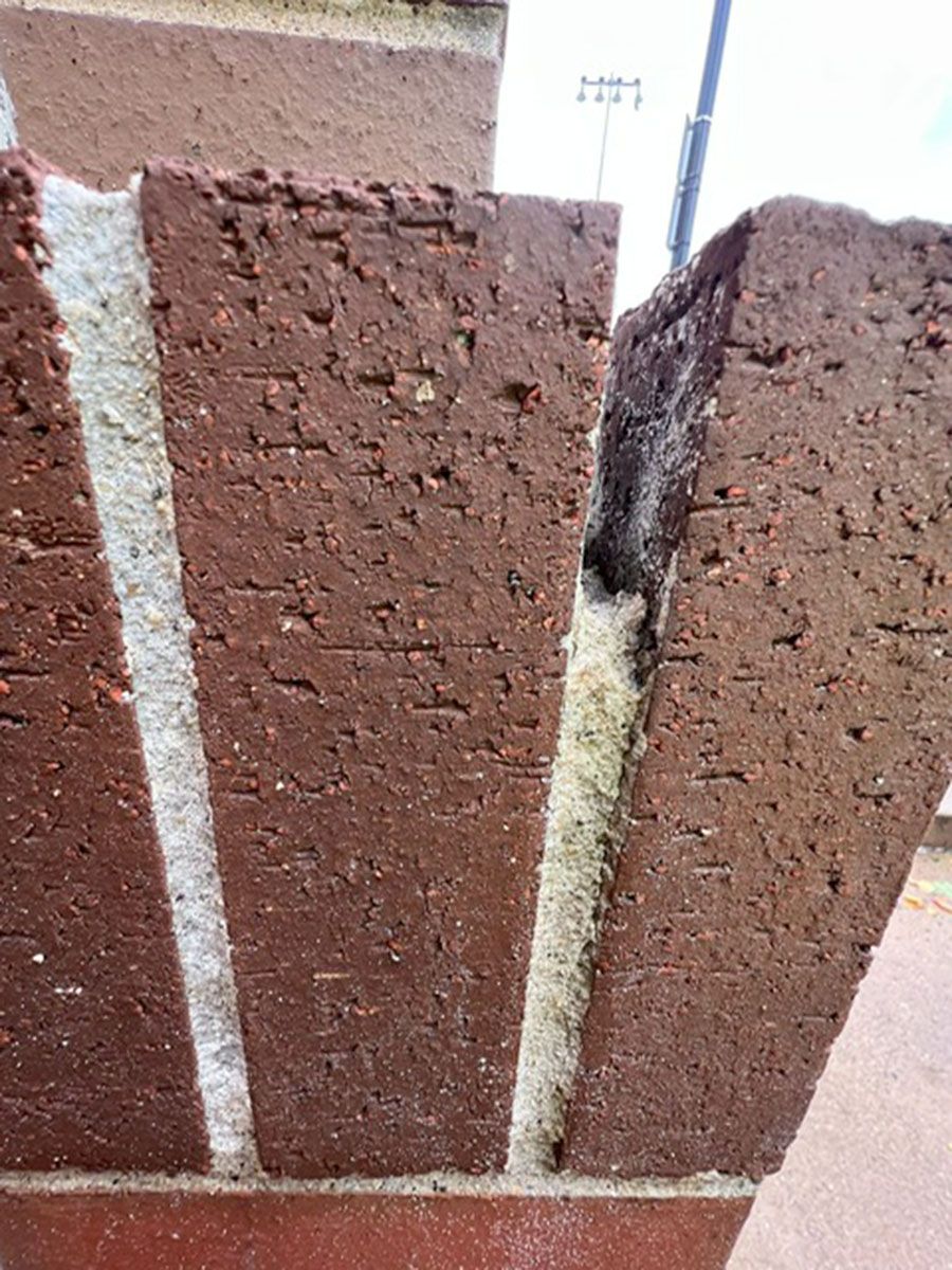 A close-up of a brick wall with a hole in it