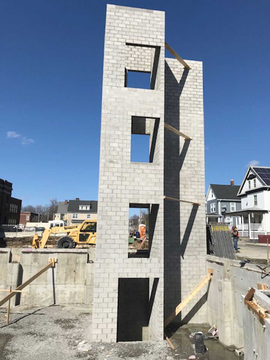 A tall brick building is being built on a construction site