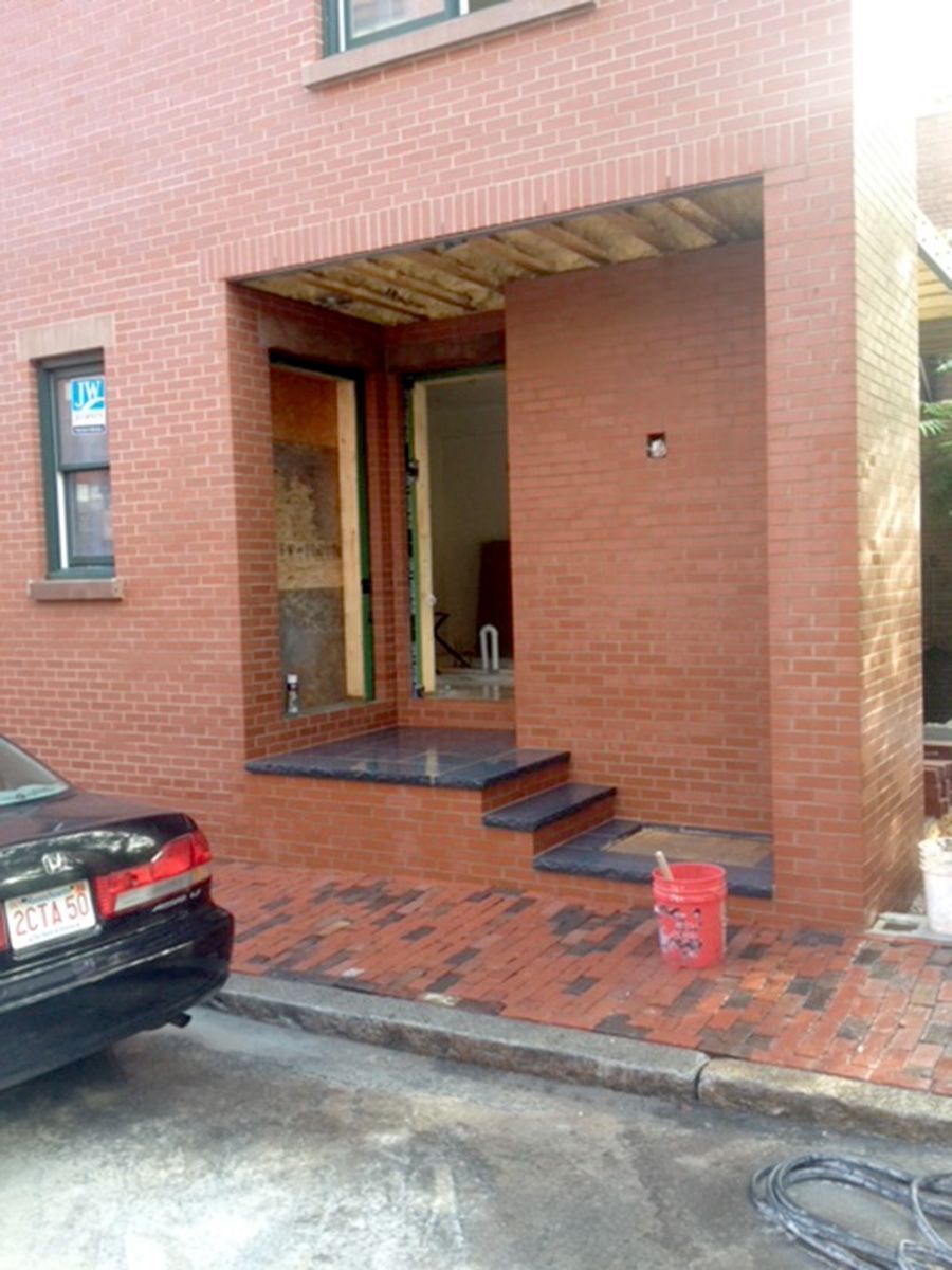 A car is parked in front of a brick building
