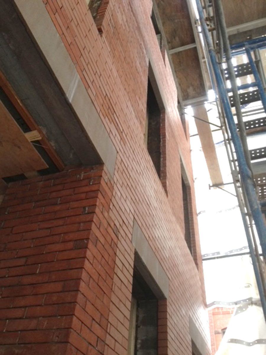 A brick building under construction with scaffolding around it