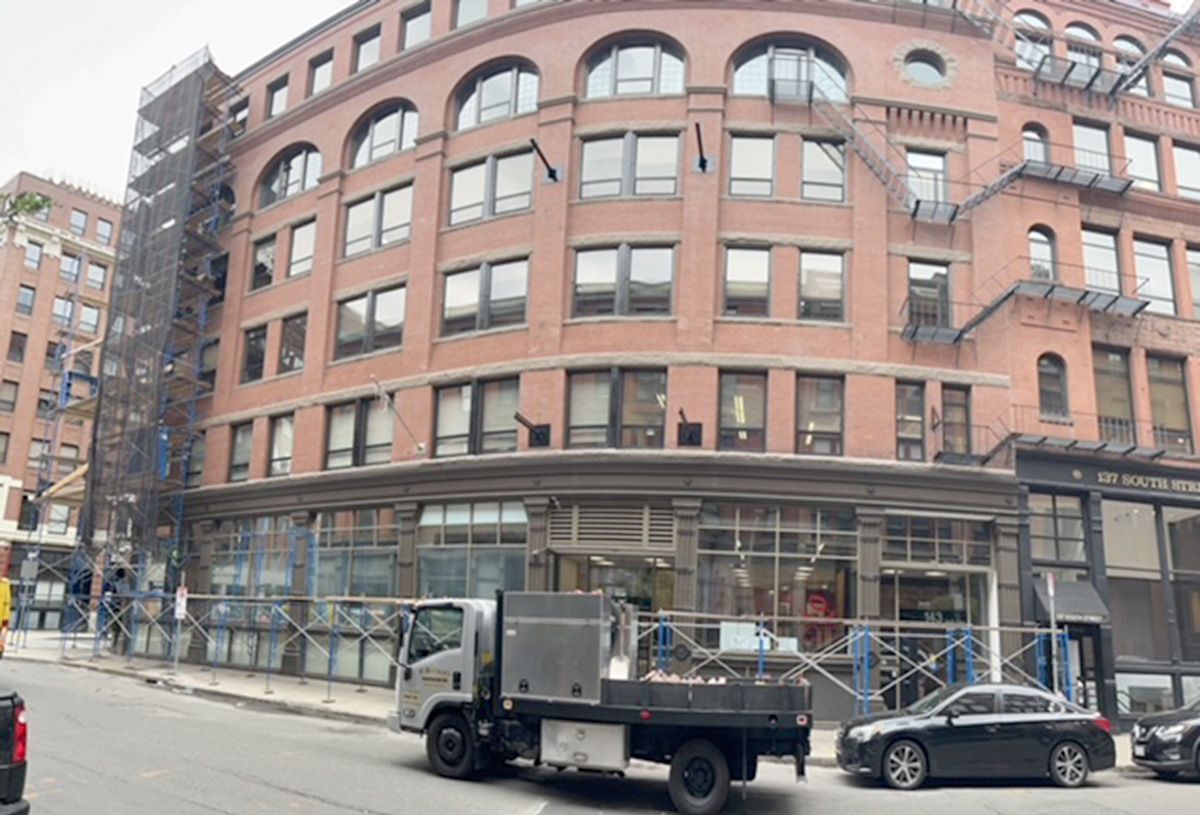 A truck is parked in front of a large brick building