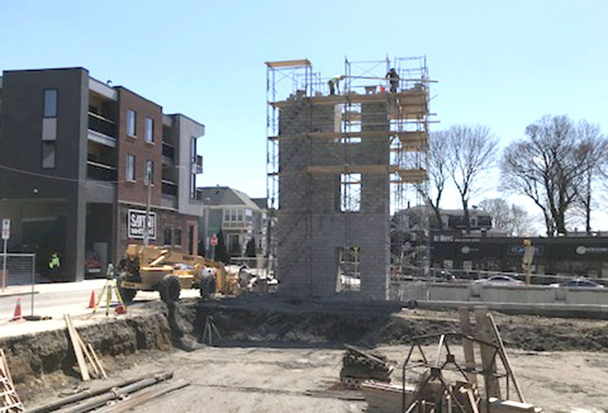 A construction site with a brick building in the background