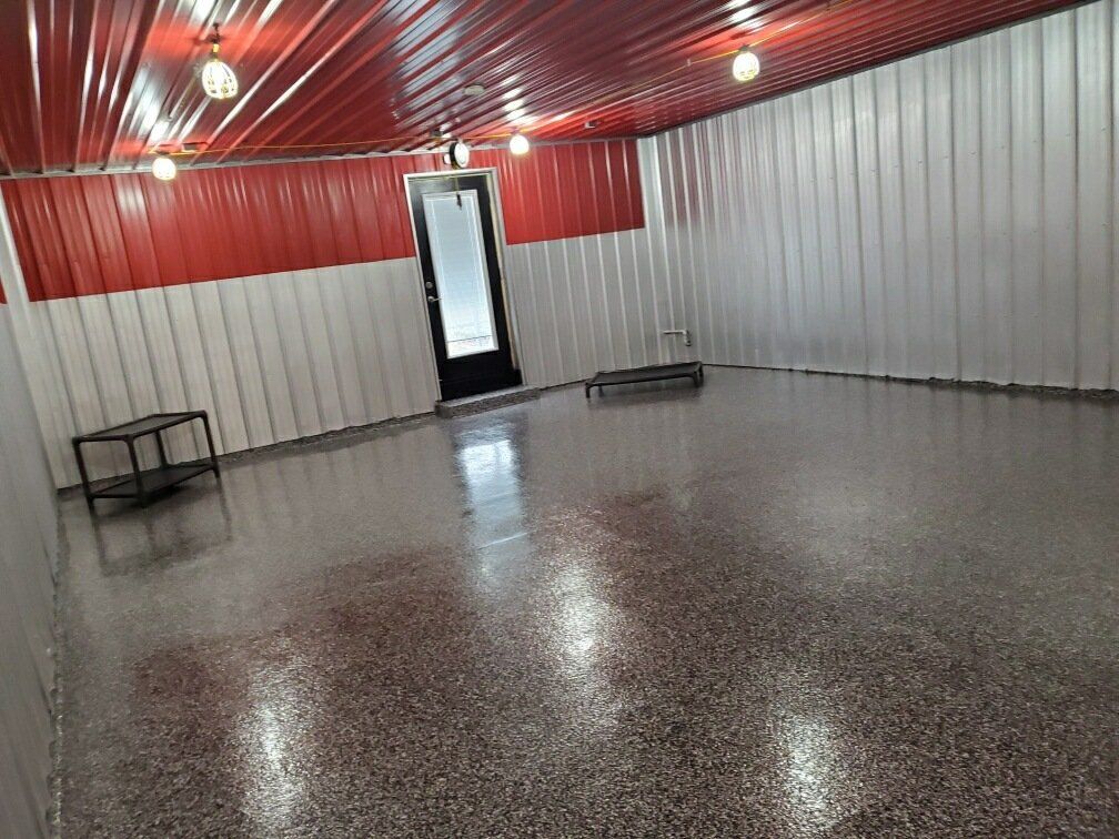 A large empty room with a gray floor and red and white walls.