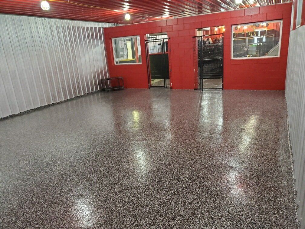 A large room with a concrete floor and red walls