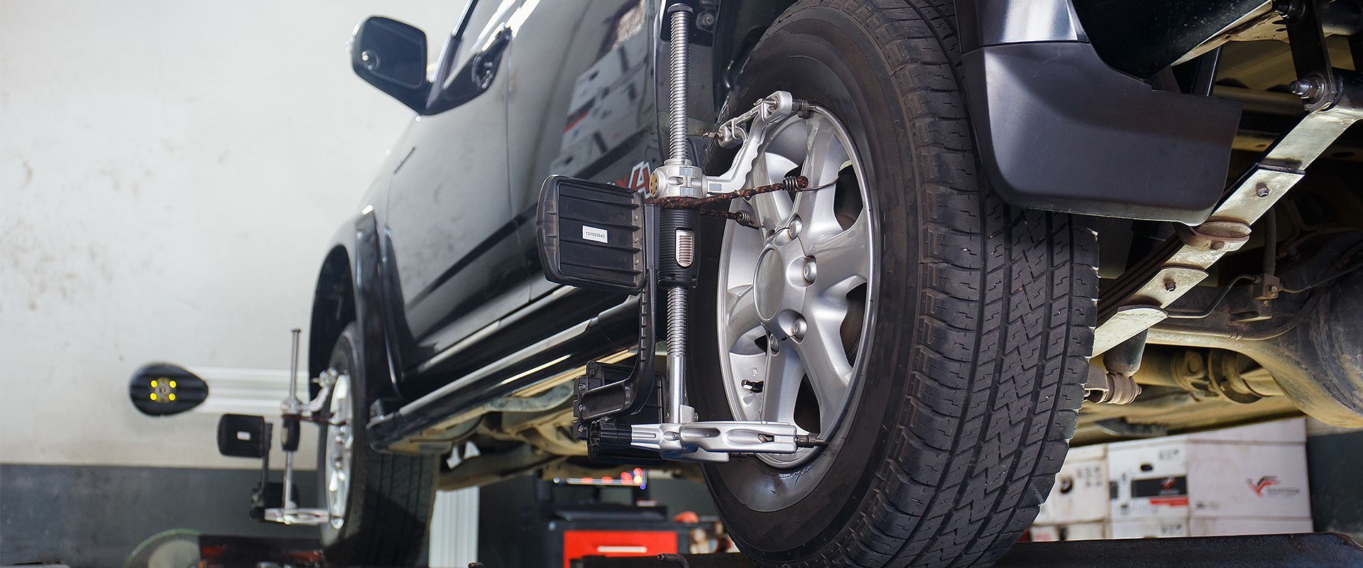 A car is being adjusted on a lift in a garage.