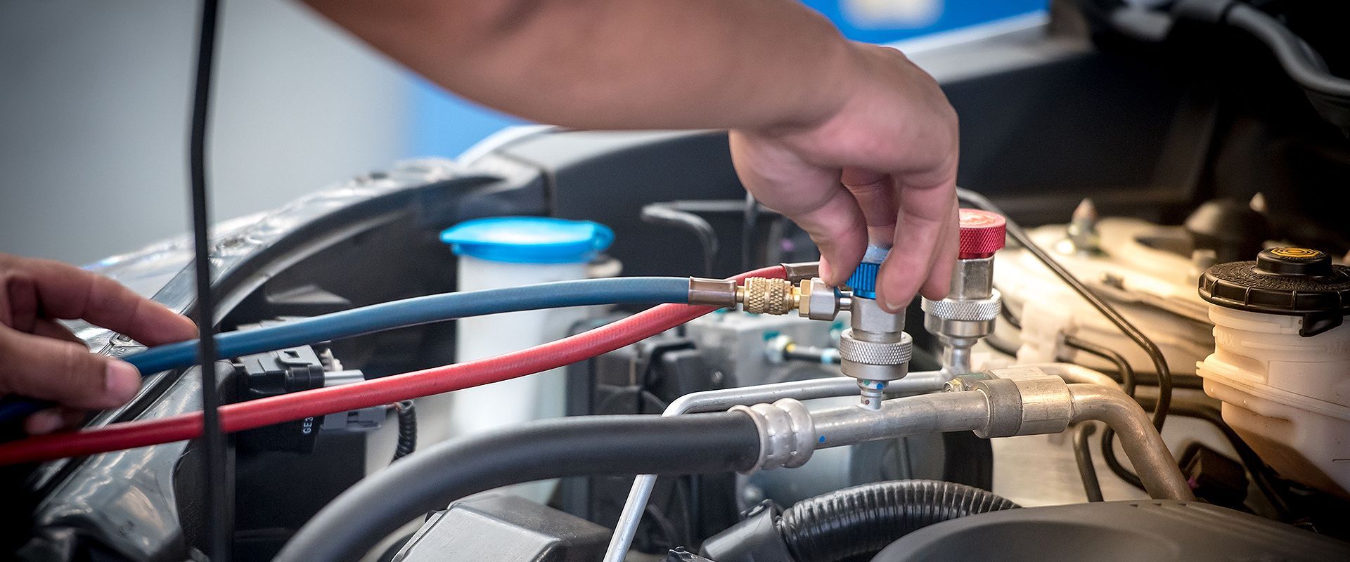 A person is working on the engine of a car.