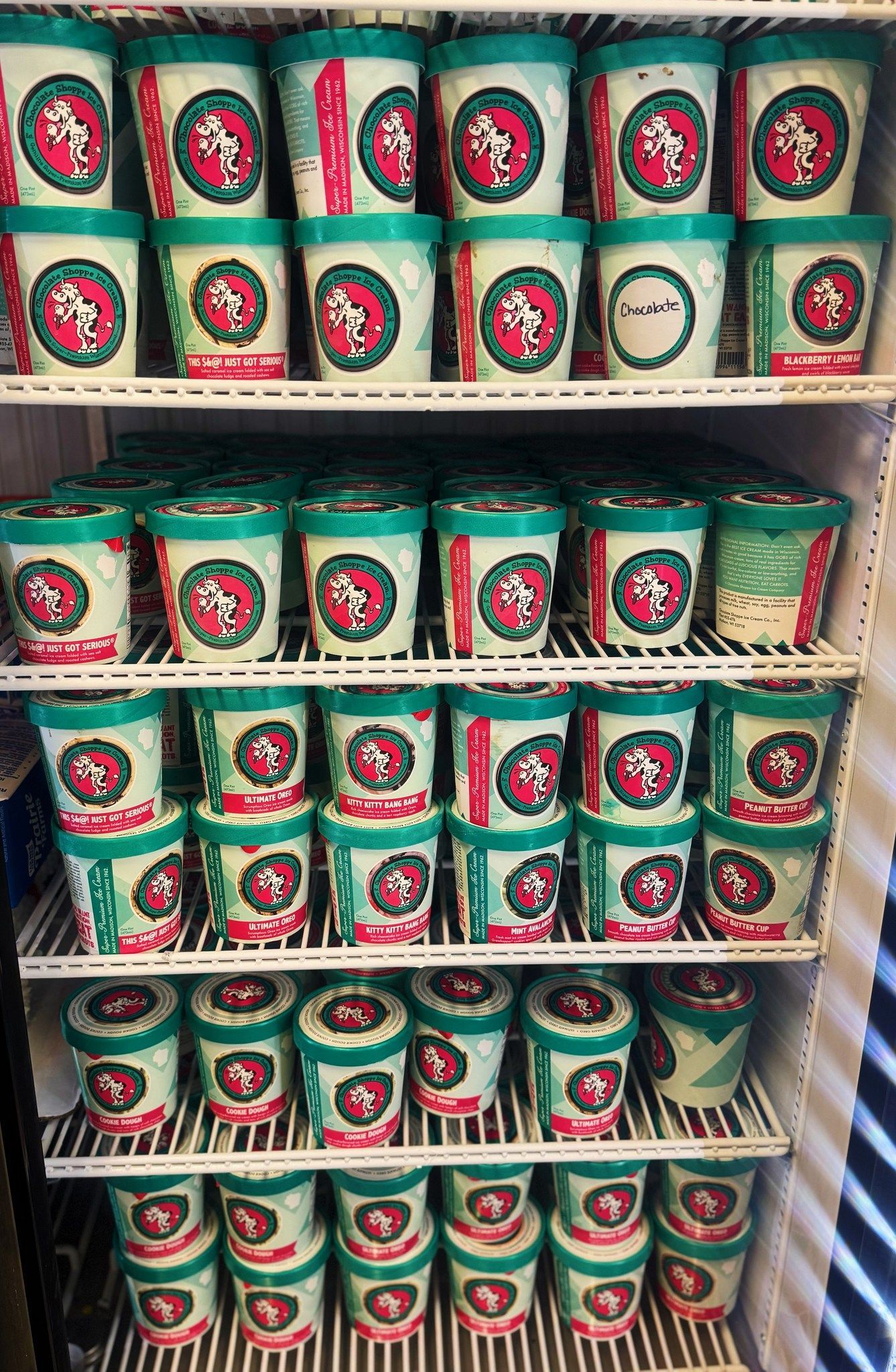 A refrigerator filled with lots of ice cream cups.