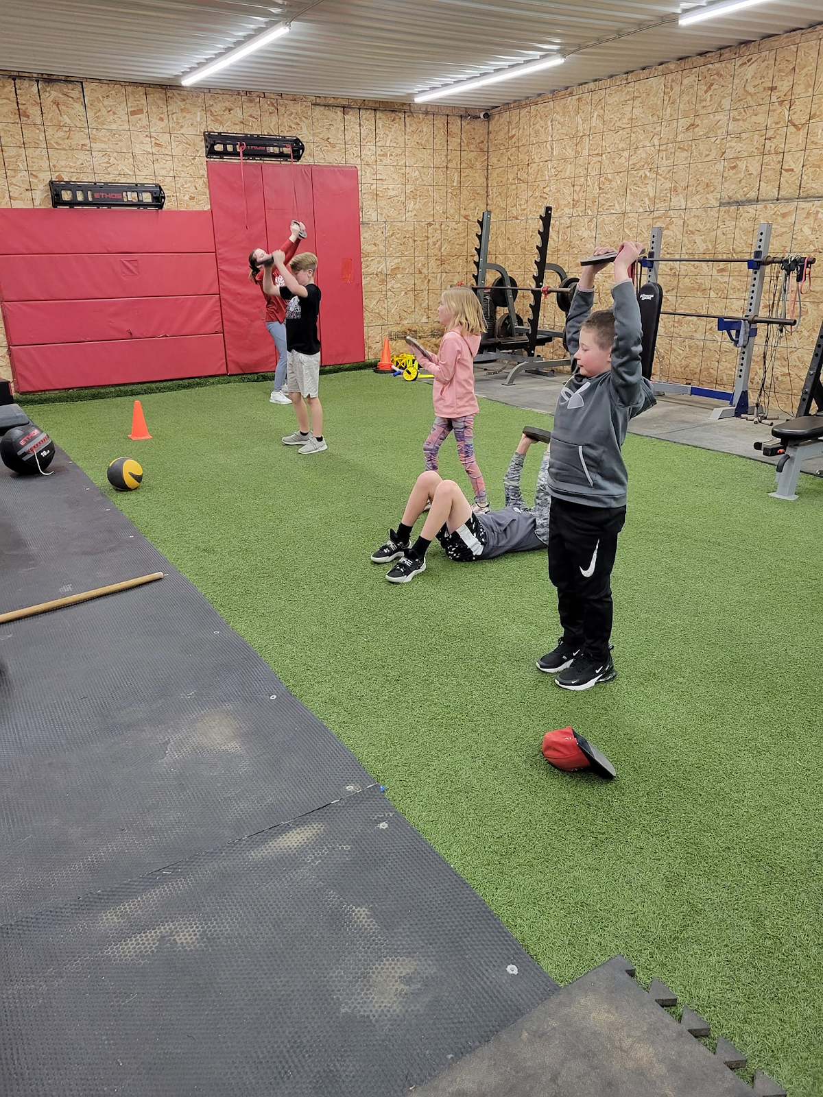 A group of children are doing exercises in a gym.