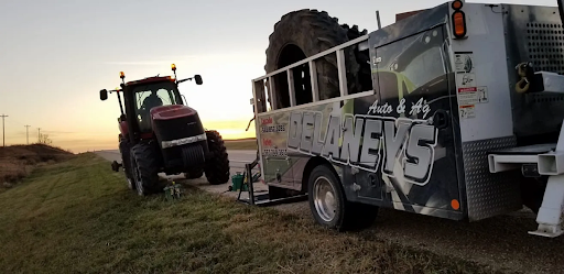 A tractor is being towed by a tow truck.