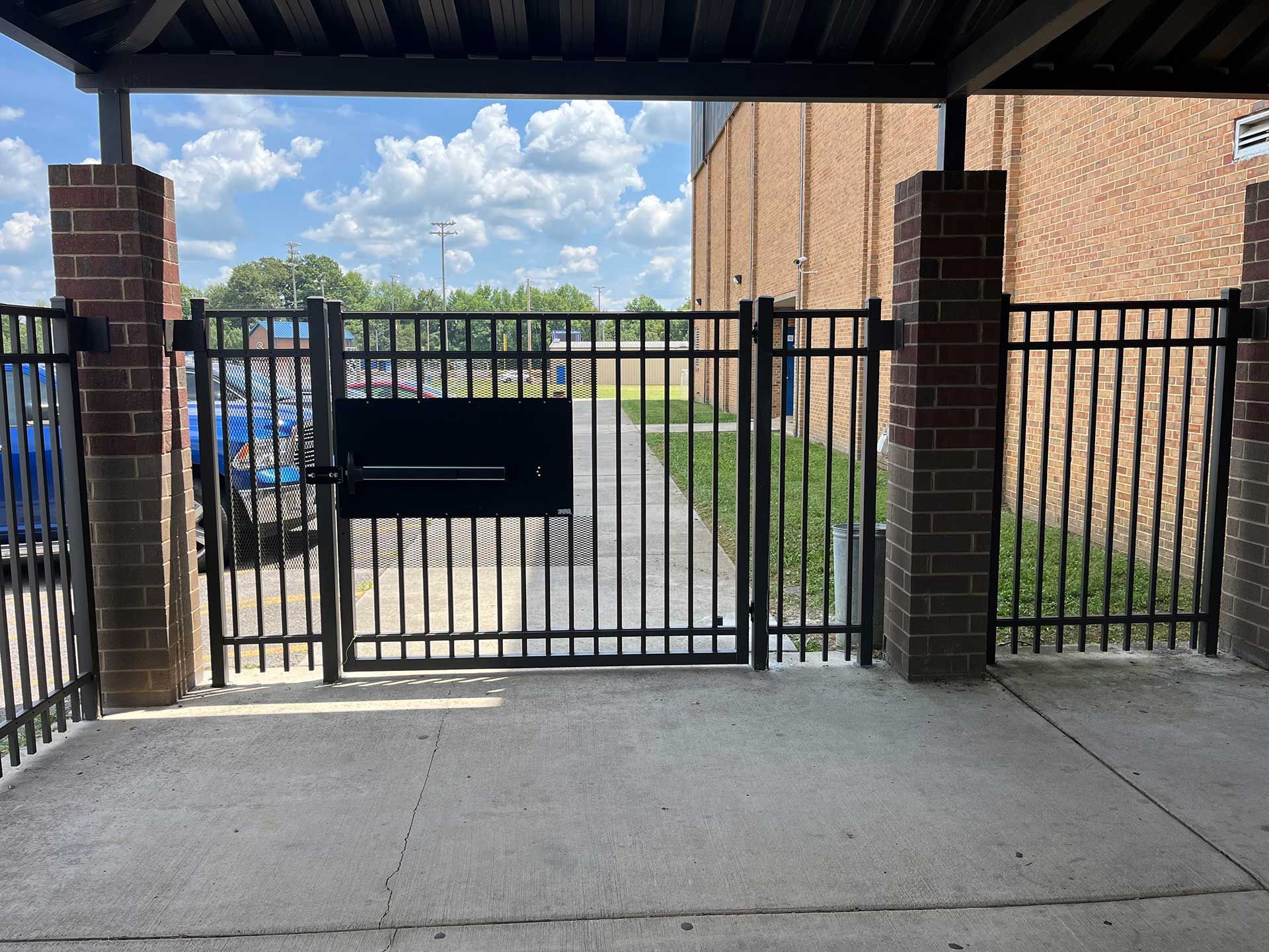 A black fence with a brick building