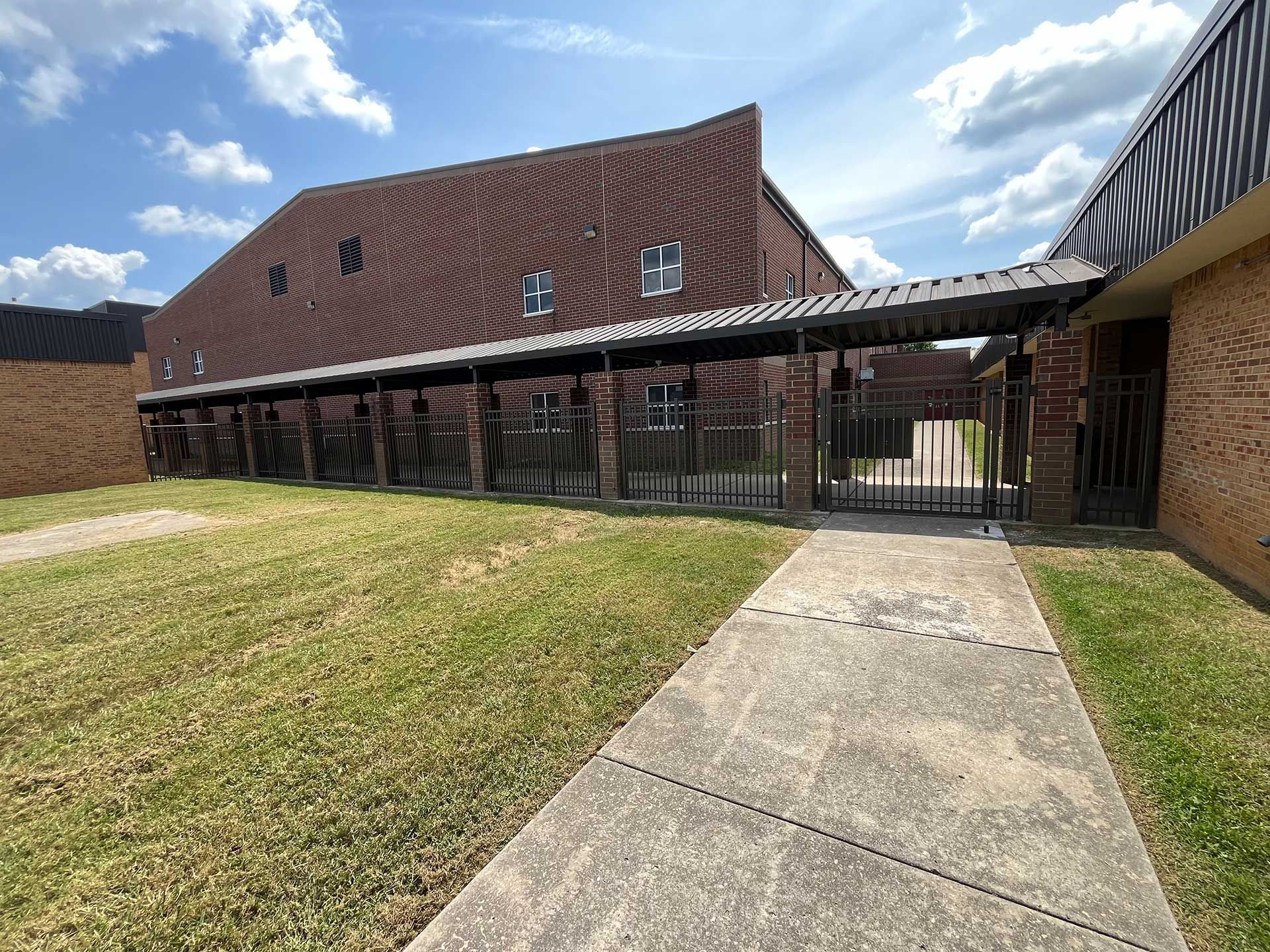 A covered walkway with a black fence