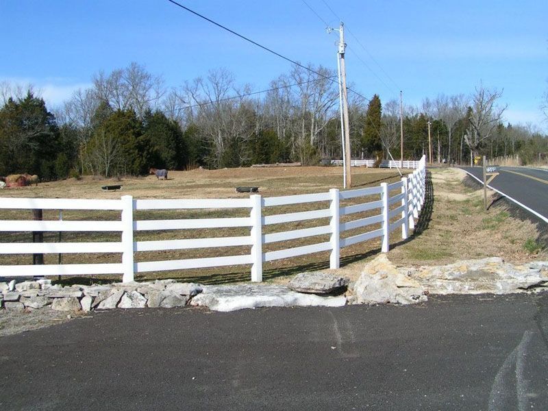 a white fence along the side of a road
