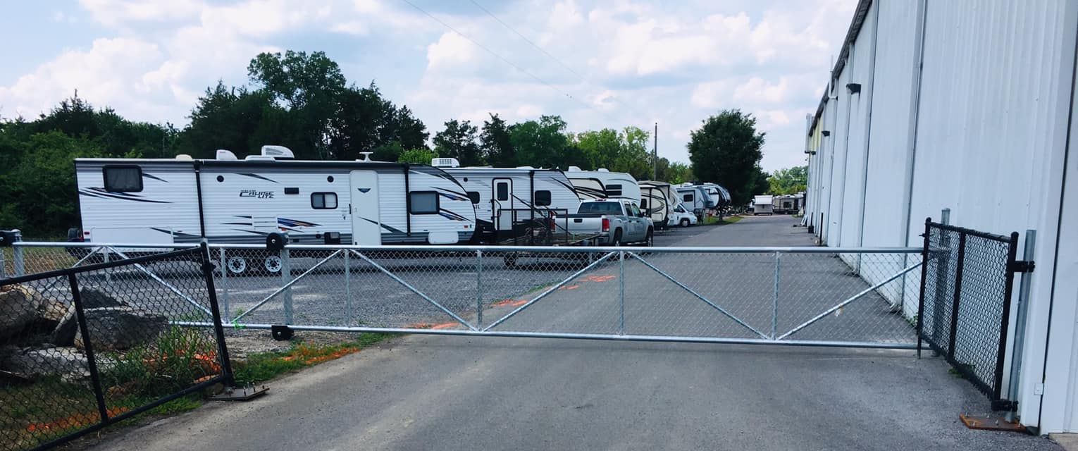 a row of rvs parked in front of a building next to a gate