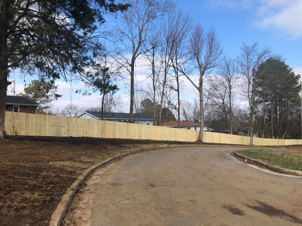 a wooden fence is along the side of a road