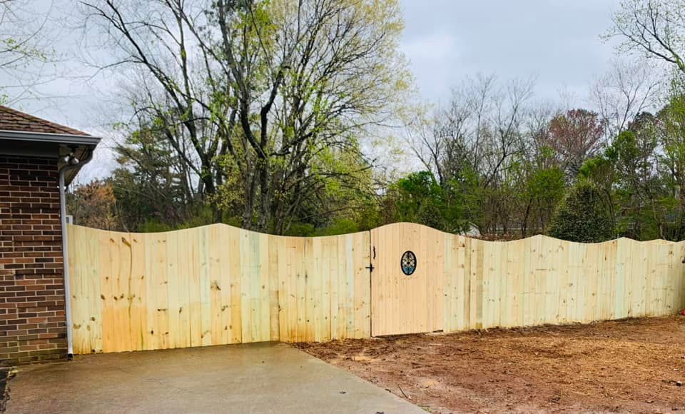 a wooden fence with a gate in front of a brick house