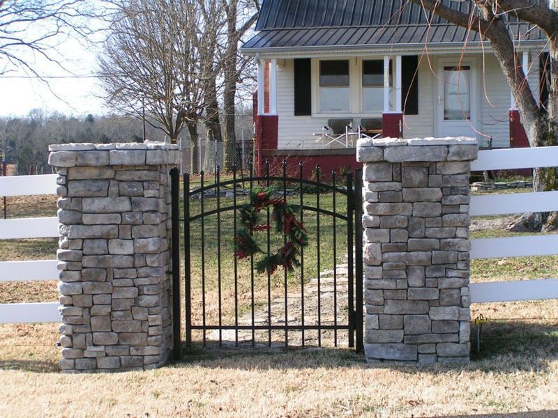 a gate with a wreath on it in front of a house
