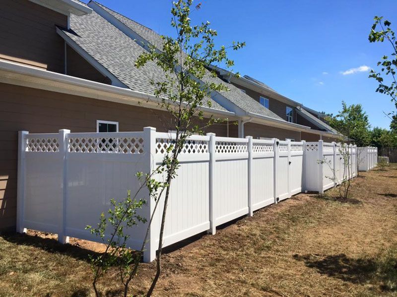 a white fence is sitting in front of a house