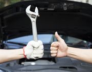 hand holding wrench and thumbs up