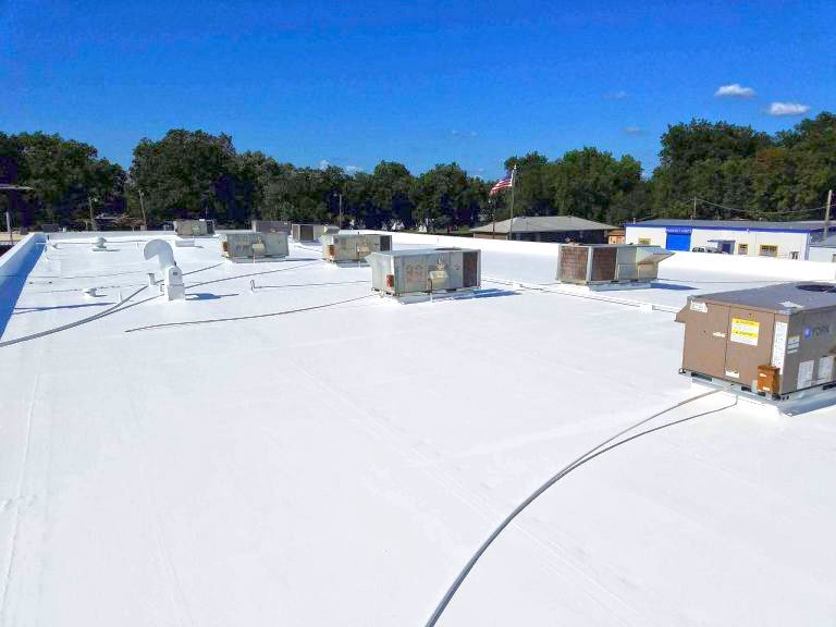 A large white roof with a lot of air conditioners on it.