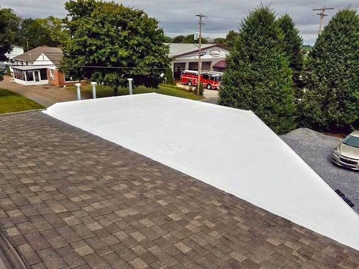 A car is parked on the roof of a house.