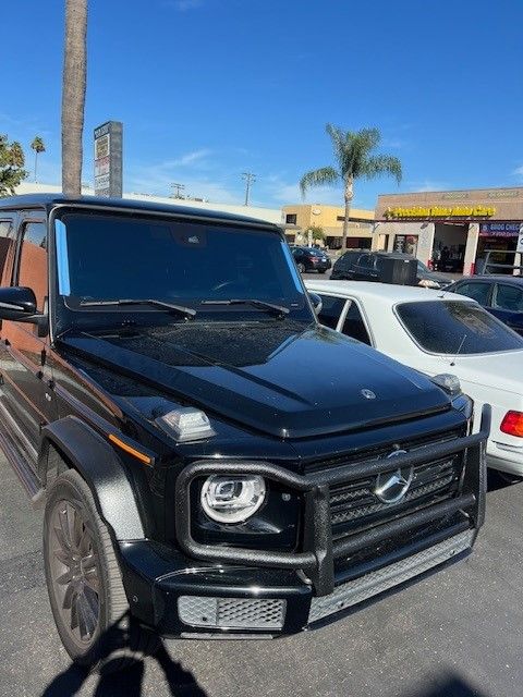 A black Mercedes Benz is parked in a parking lot.
