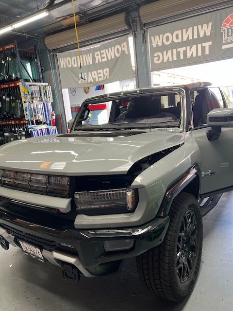 A gray suv is parked in a garage with its doors open.