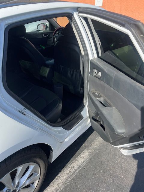 The back seat of a white car with the door open