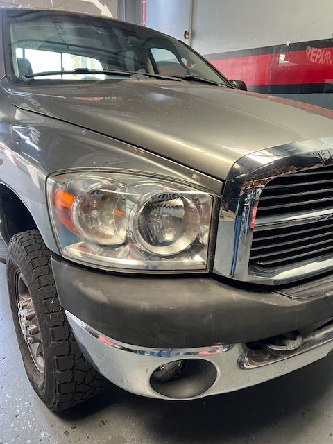A gray dodge ram truck is parked in a garage.
