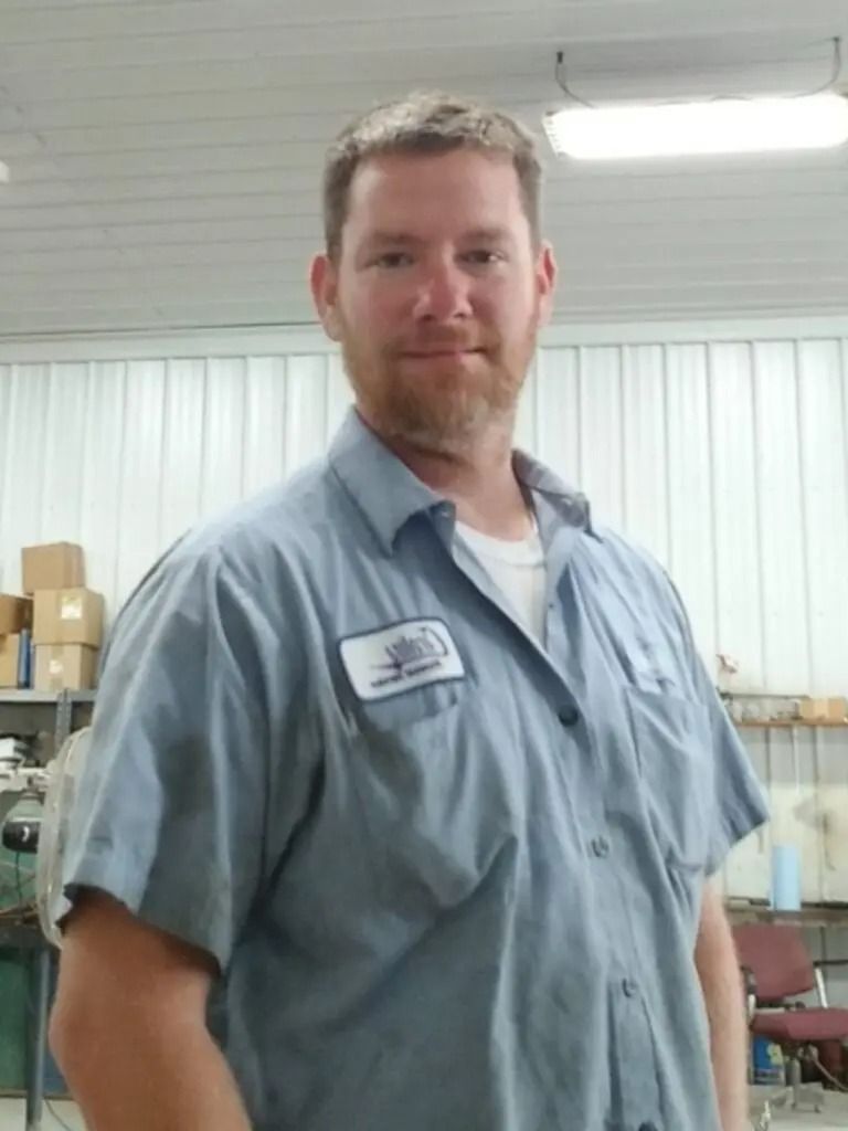 A man wearing a blue shirt with a name tag on his chest