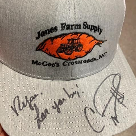 A hat that says jones farm supply on it.