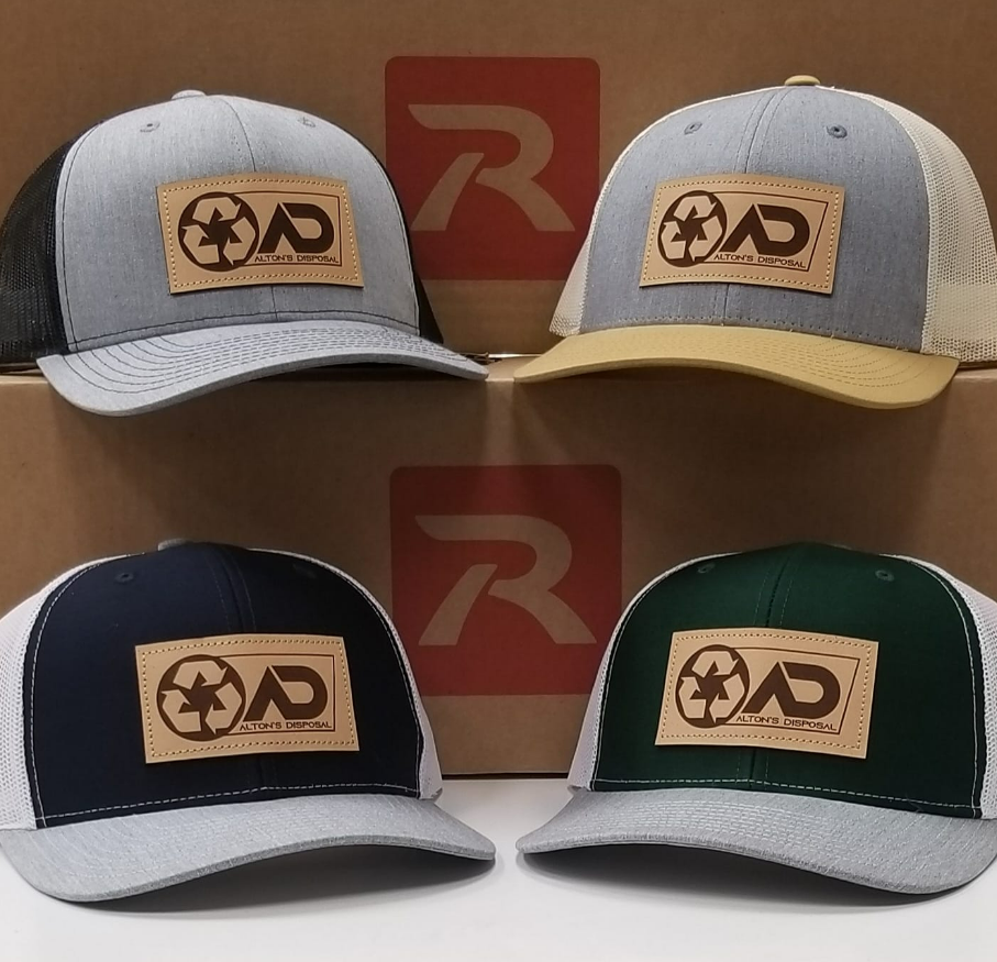Four dad hats are sitting in front of a cardboard box.