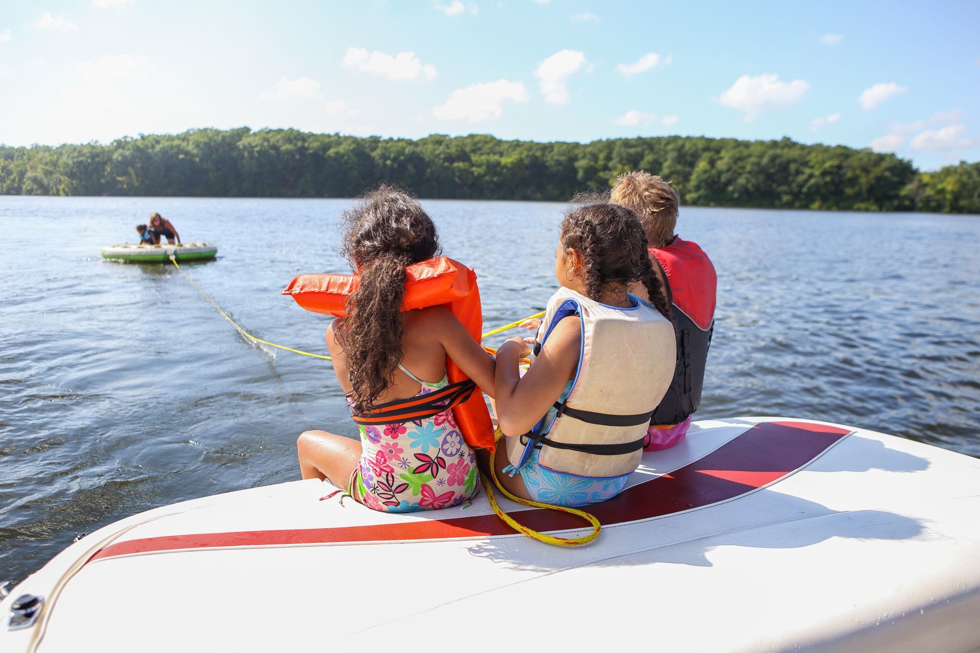 Lake scene with three children on a boat