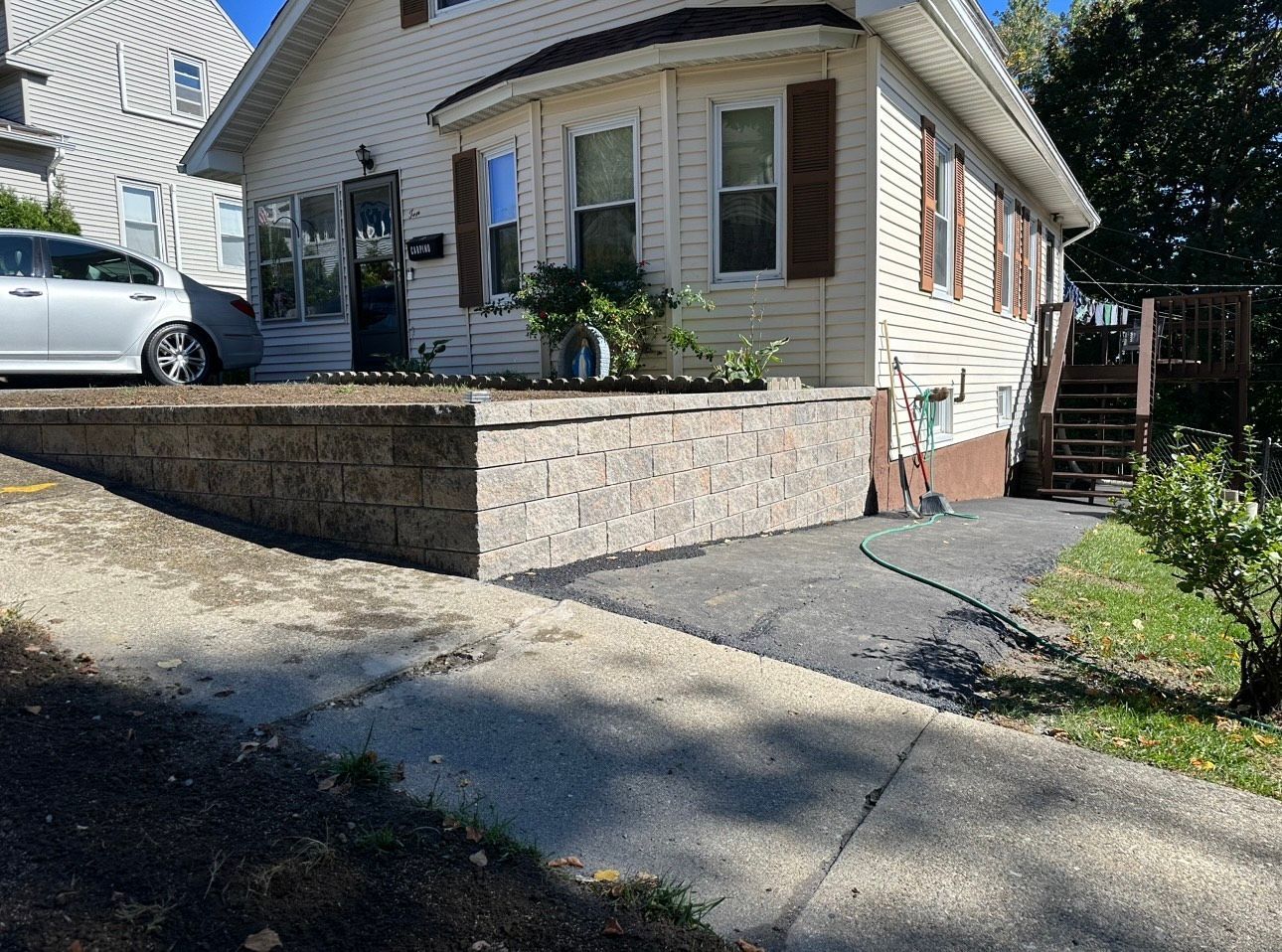 A white house with a car parked in front of it.