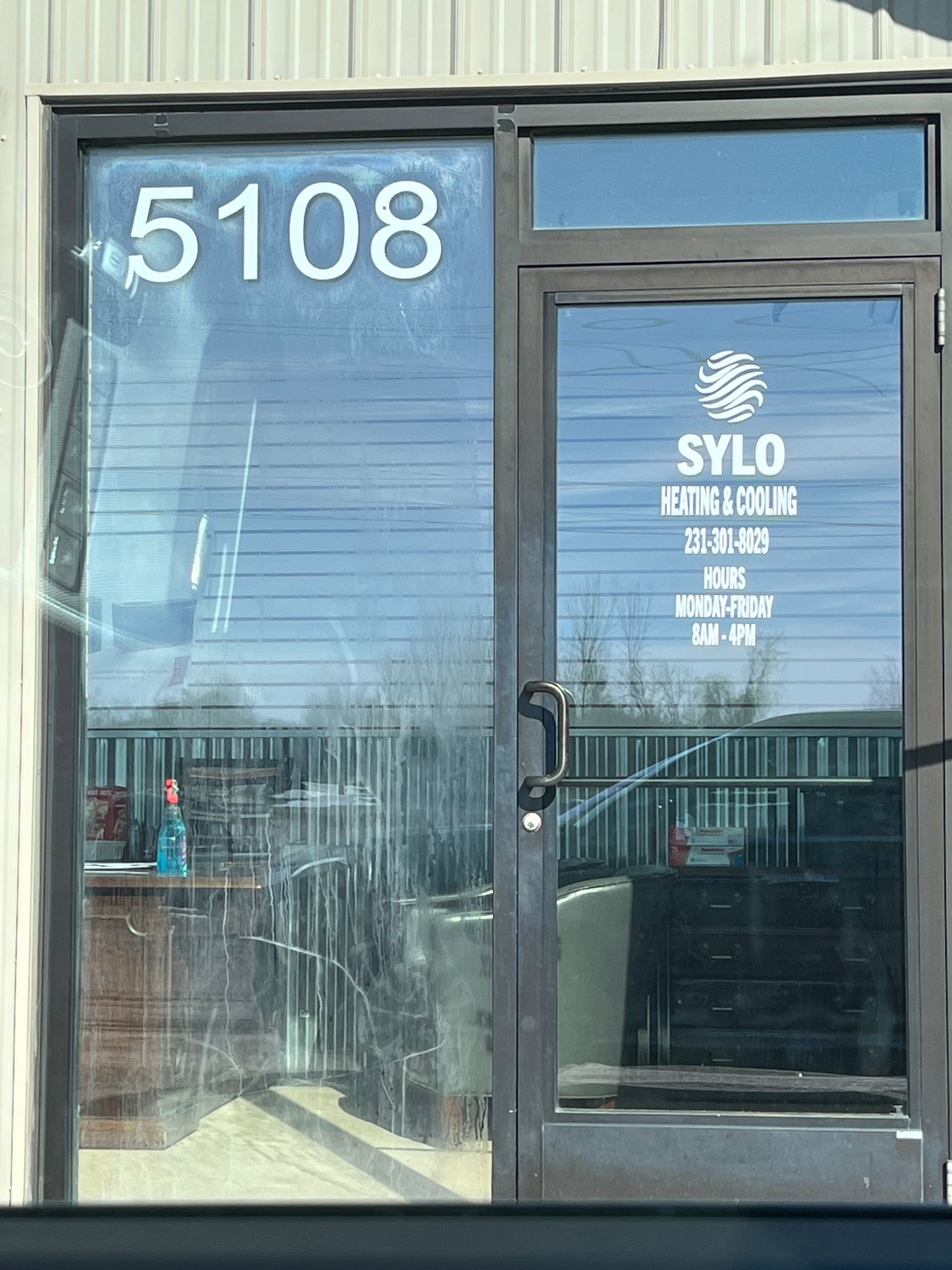 The storefront entrance of Sylo Heating & Cooling at address 5108, featuring a glass door and window.