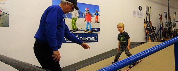 a trainer teaching a child in skiing