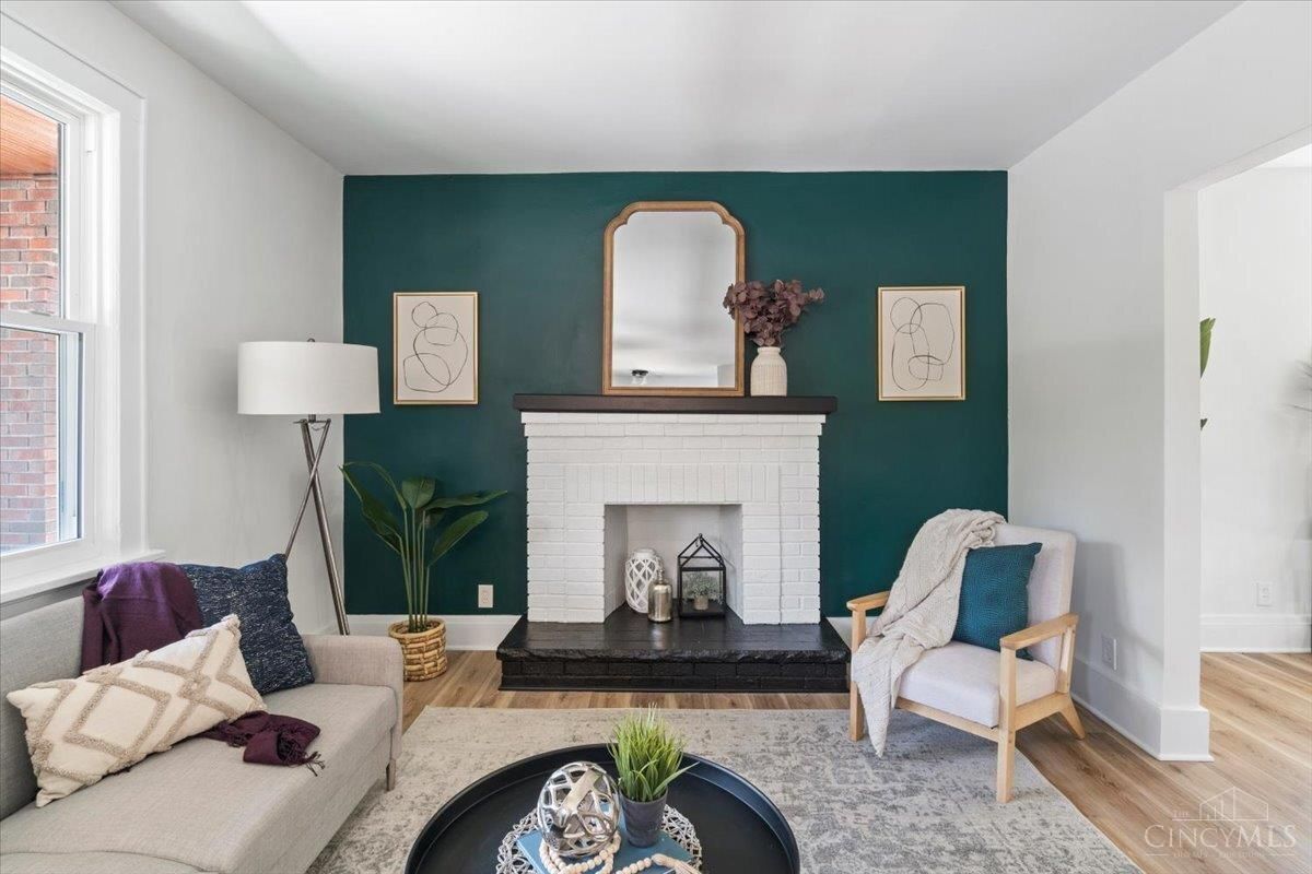Living room with teal accent wall, white fireplace, and beige sofa.