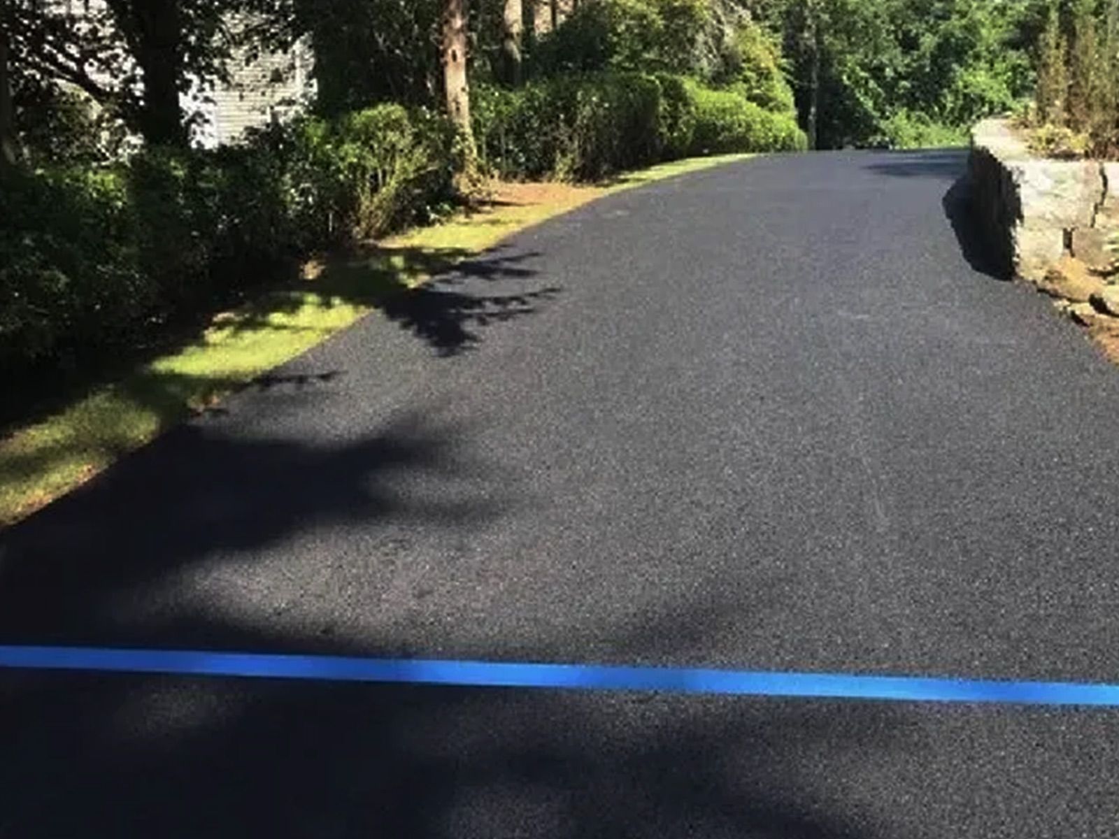 A black asphalt road with a blue line on the side of it.