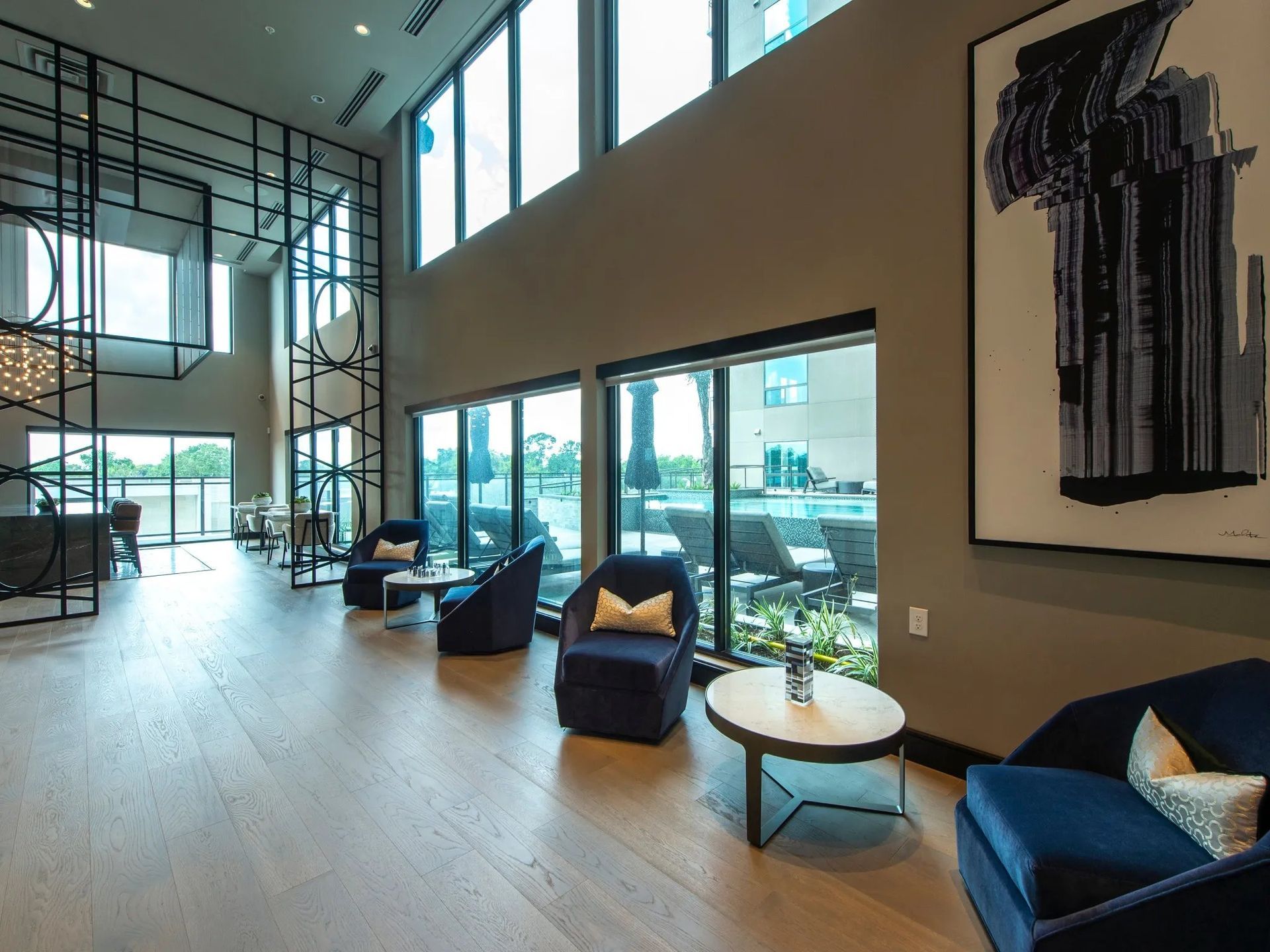 Modern lobby lounge with blue chairs, large windows, and abstract wall art