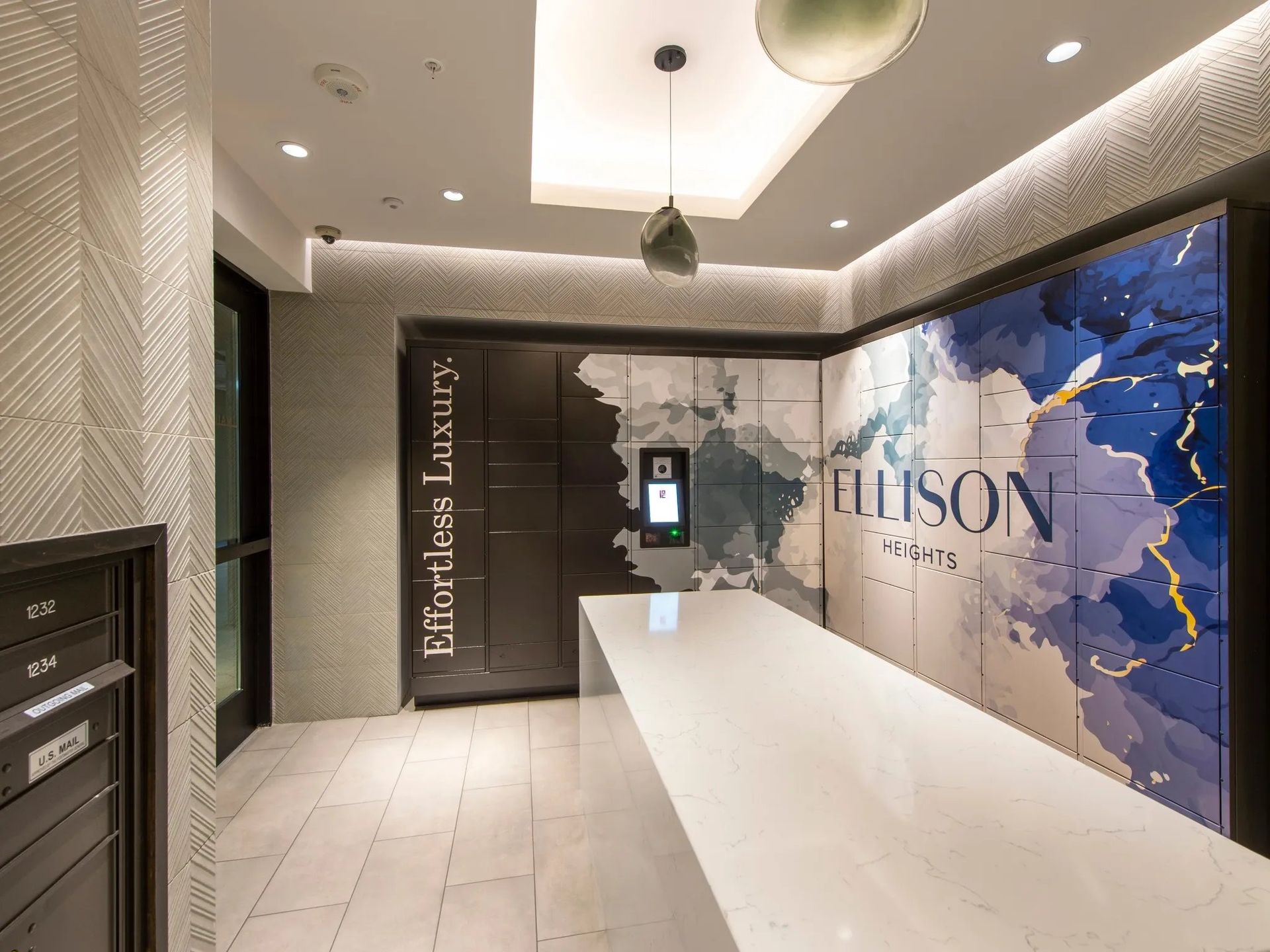Modern lobby reception with white counter, marble walls, and blue abstract art panel