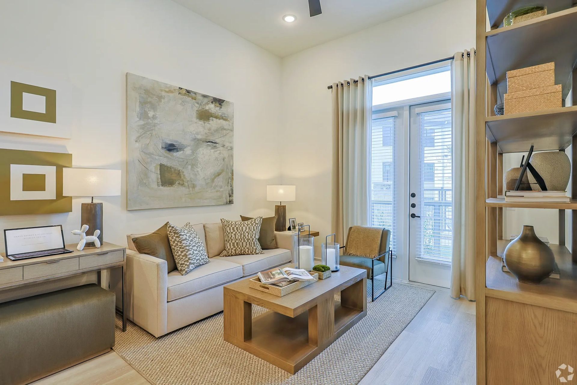 Bright modern living room with beige sofa, coffee table, and large window with sheer curtains