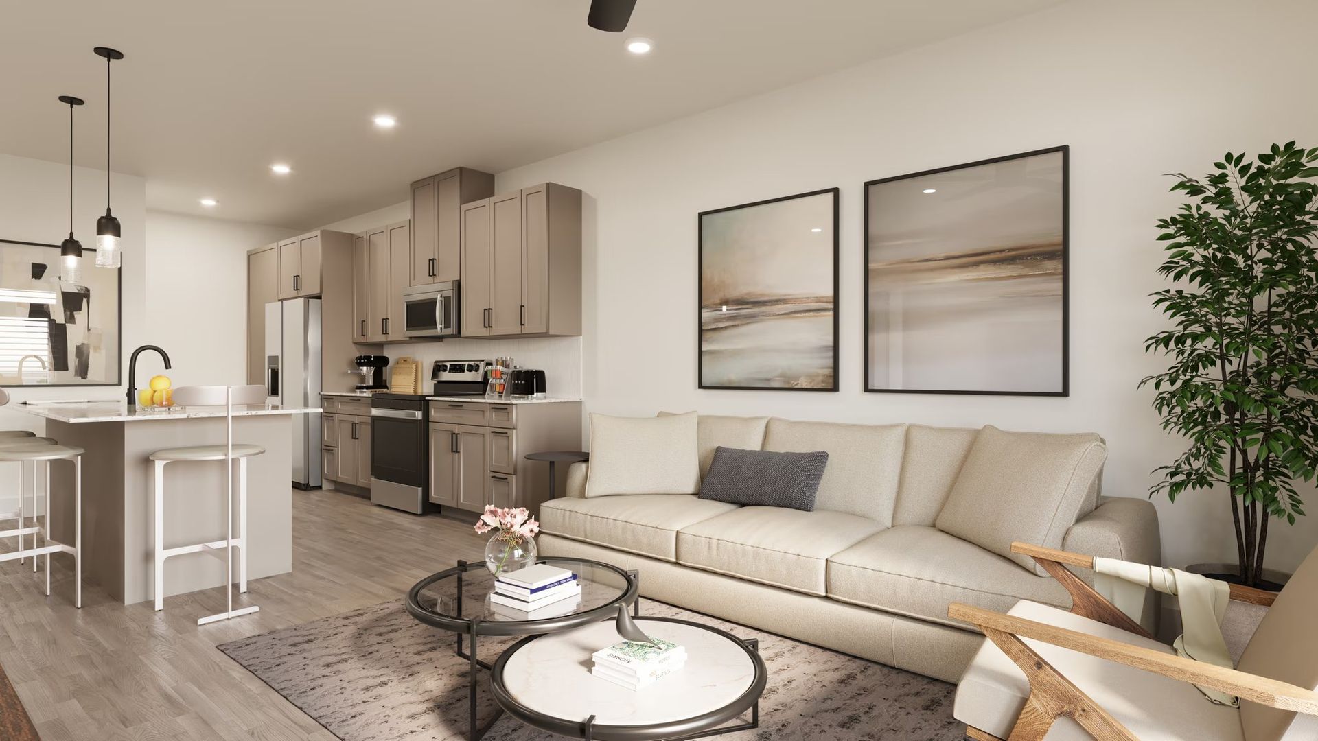 Modern open-concept living room and kitchen with beige sofa, round coffee table, and bright neutral decor.