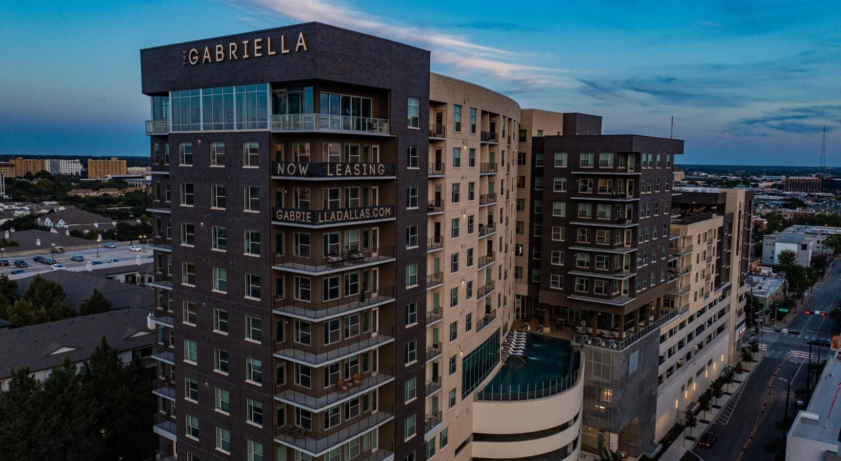 Aerial view of the Cabrillo apartment complex at dusk, with city streets and buildings in the background.