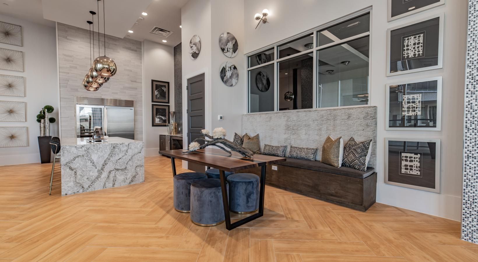 Modern living room with wood floors, gray sofa, marble coffee table, and wall art.